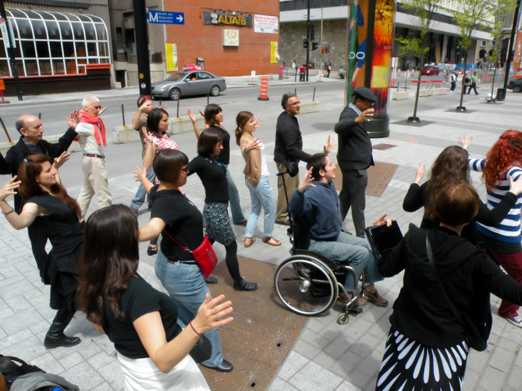 Picture of a workshop on creative movement: a dozen participants frozen on a montreal street